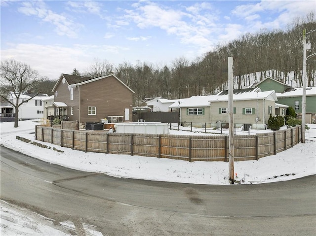 yard covered in snow featuring a residential view and fence private yard