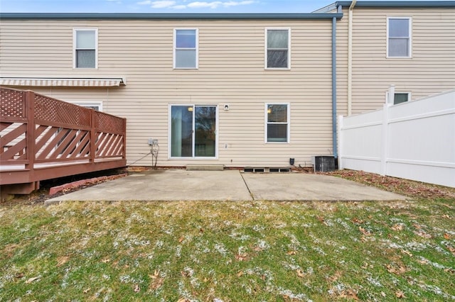 rear view of property featuring a patio, a fenced backyard, a deck, a yard, and central AC