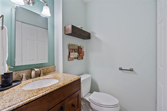 half bathroom featuring toilet and vanity