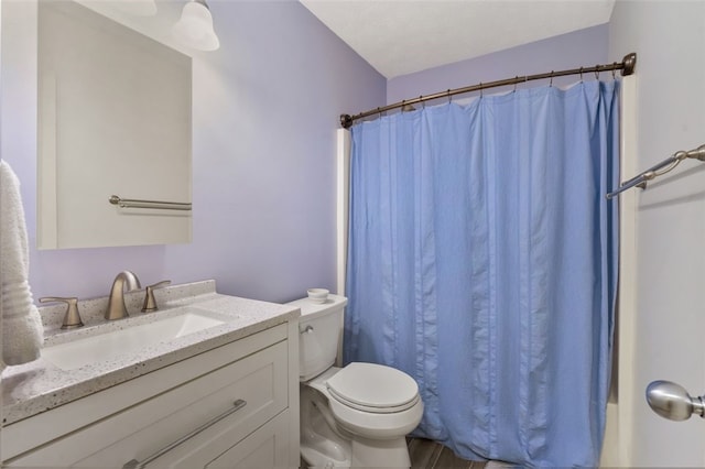 bathroom with toilet, curtained shower, and vanity