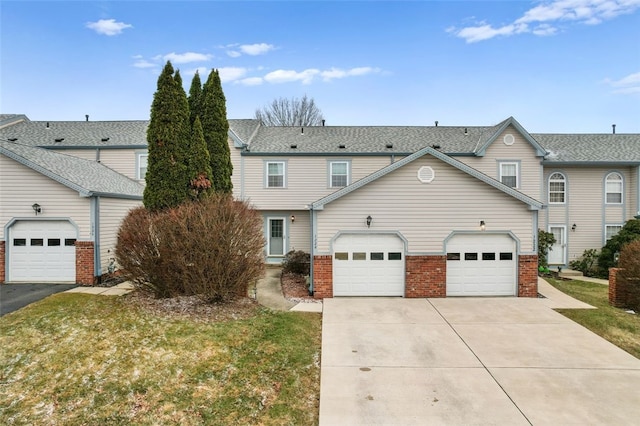 view of property with a garage, driveway, and brick siding