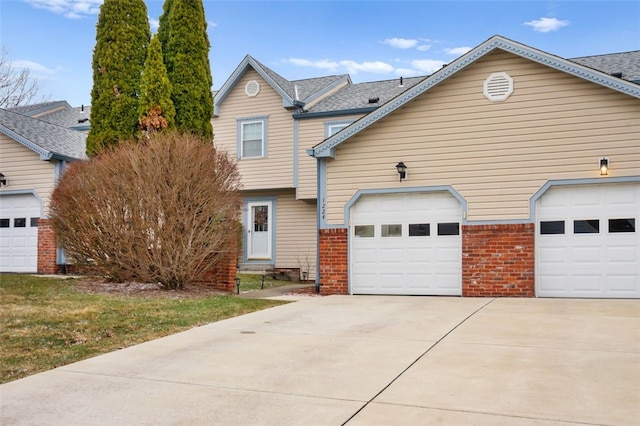 view of front of property with driveway, a garage, and brick siding