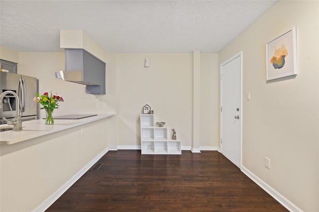 interior space with dark wood-style flooring, visible vents, a textured ceiling, and baseboards