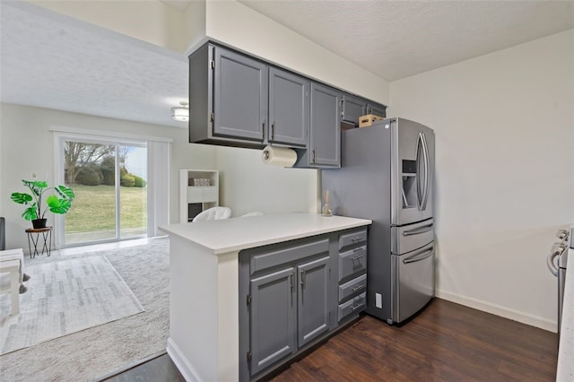 kitchen featuring stainless steel fridge, dark wood-style flooring, light countertops, and gray cabinetry