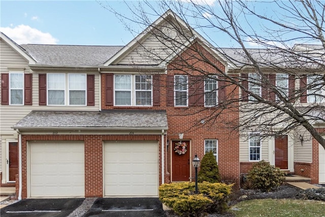 view of property featuring driveway, a shingled roof, an attached garage, and brick siding