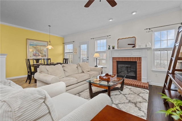 living area with ornamental molding, a wealth of natural light, and wood finished floors