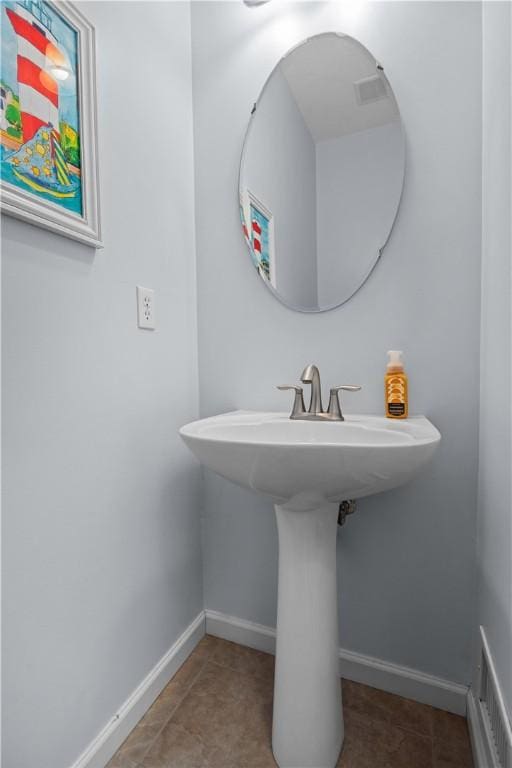 bathroom with a sink, tile patterned flooring, and baseboards