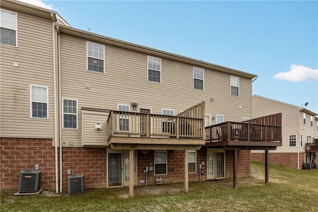 back of property featuring a lawn, a wooden deck, and central air condition unit