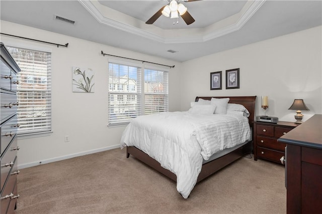 bedroom featuring a raised ceiling, visible vents, ornamental molding, light carpet, and baseboards