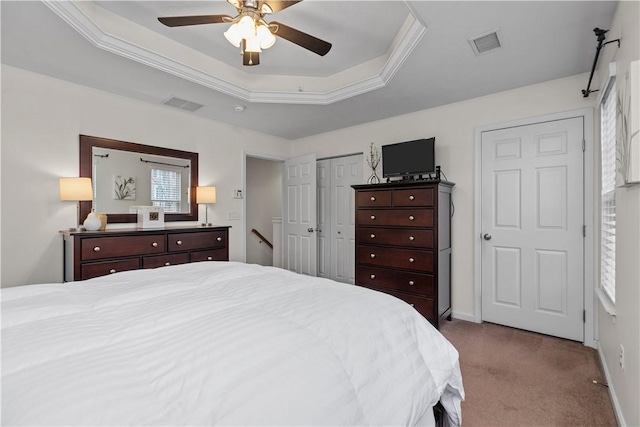 bedroom featuring carpet, a raised ceiling, visible vents, and baseboards