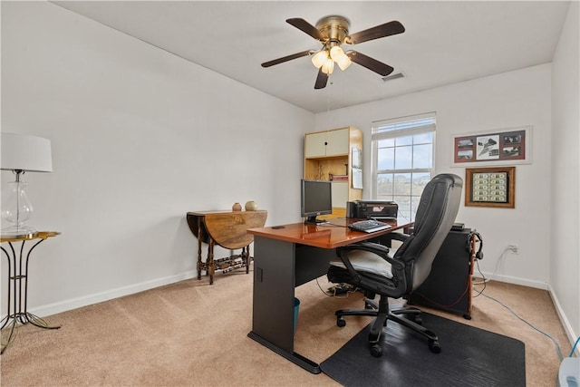 office space with a ceiling fan, light colored carpet, visible vents, and baseboards