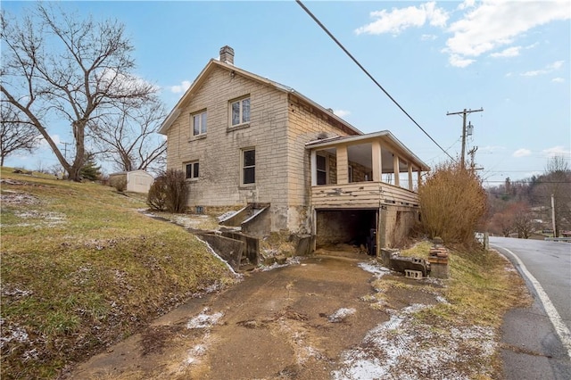 view of side of property with a garage, driveway, and a chimney