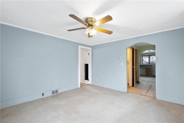 spare room featuring arched walkways, visible vents, crown molding, and tile patterned floors