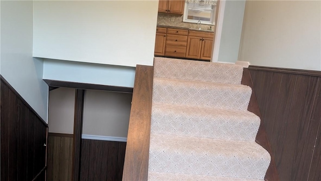 stairs with a wainscoted wall