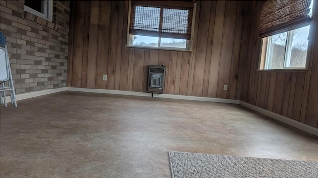 empty room with heating unit, plenty of natural light, and finished concrete floors