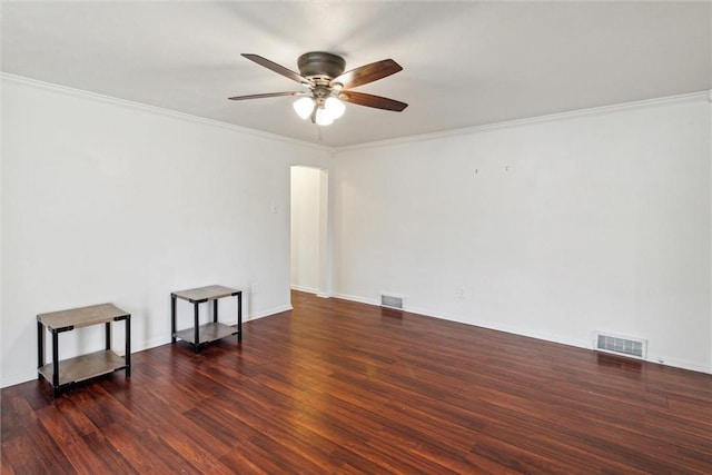 spare room with crown molding, visible vents, ceiling fan, and wood finished floors