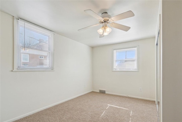 unfurnished room with a ceiling fan, carpet, visible vents, and baseboards