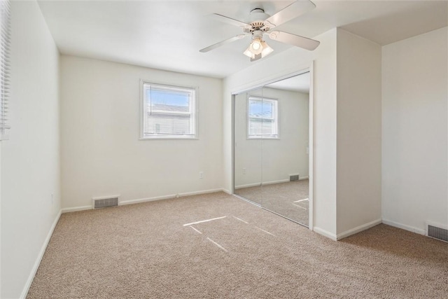 unfurnished bedroom featuring carpet floors, a closet, visible vents, and baseboards