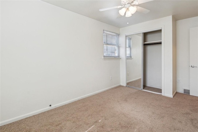 unfurnished bedroom featuring carpet flooring, a ceiling fan, visible vents, baseboards, and a closet