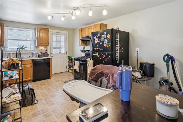 kitchen featuring black appliances, light floors, and under cabinet range hood