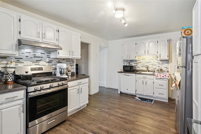 kitchen featuring under cabinet range hood, stainless steel appliances, a sink, white cabinets, and dark wood-style floors