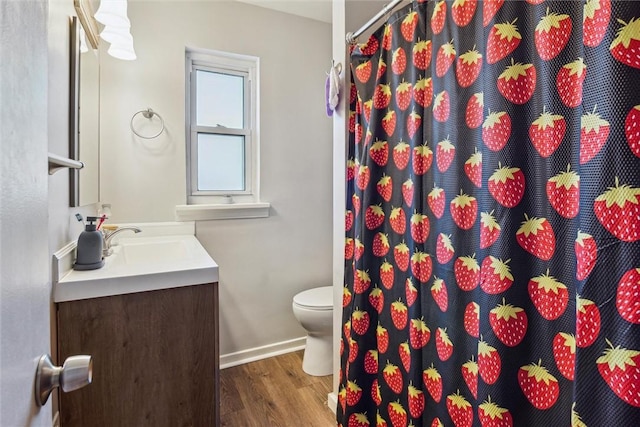 full bath with toilet, vanity, wood finished floors, a shower with curtain, and baseboards