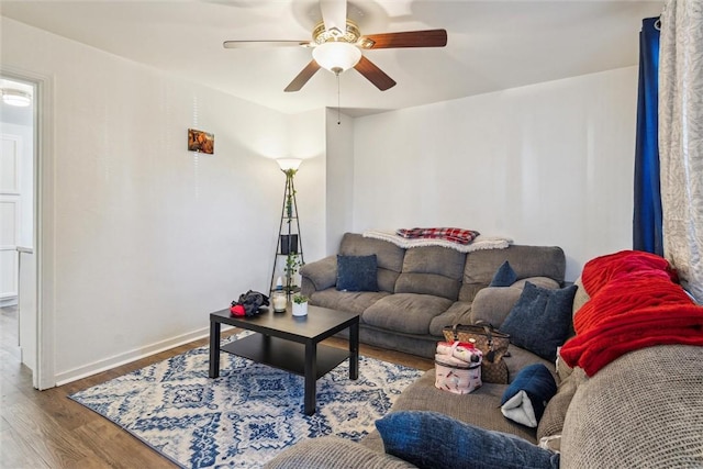 living area with a ceiling fan, baseboards, and wood finished floors