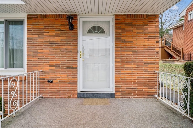 view of exterior entry featuring brick siding