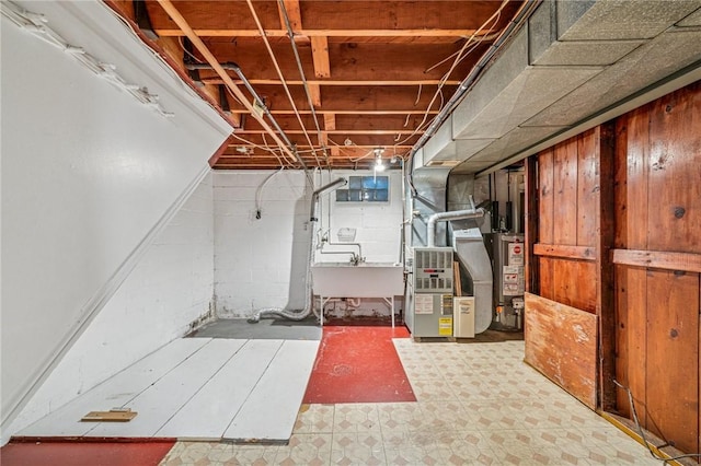 unfinished below grade area with gas water heater, a sink, and tile patterned floors