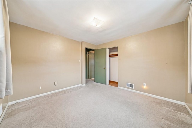 spare room featuring baseboards, visible vents, and carpet flooring