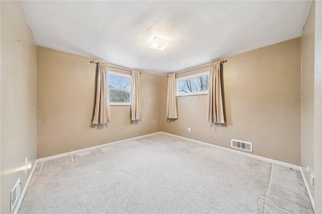 unfurnished room featuring carpet floors, visible vents, and baseboards