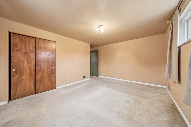 unfurnished bedroom with light colored carpet and baseboards