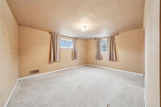 empty room with carpet floors, baseboards, and visible vents