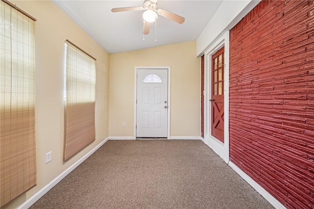 doorway to outside featuring carpet, baseboards, and ceiling fan