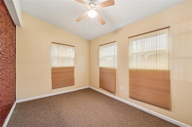 unfurnished room featuring carpet floors, vaulted ceiling, baseboards, and ceiling fan