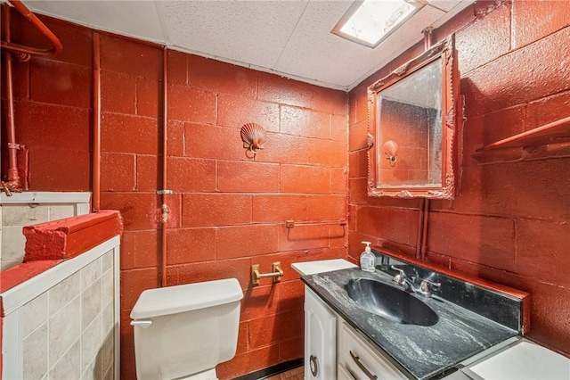 bathroom featuring vanity and concrete block wall