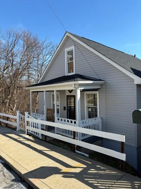 view of front facade featuring a porch and fence