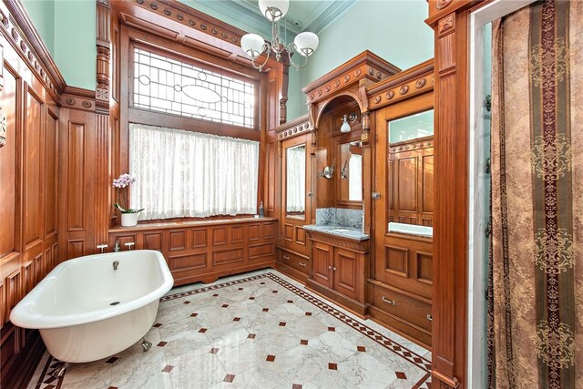 bathroom with a chandelier, a freestanding tub, a high ceiling, vanity, and crown molding