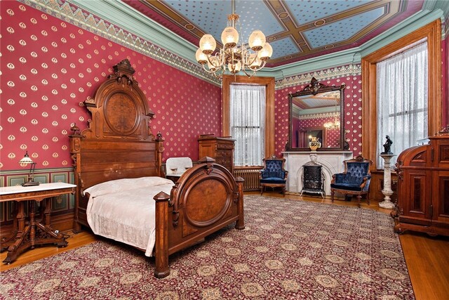 bedroom with wallpapered walls, a notable chandelier, multiple windows, and wood finished floors