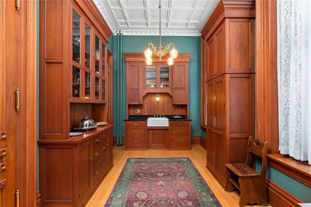 home office featuring a sink, light wood-style floors, an ornate ceiling, and a notable chandelier