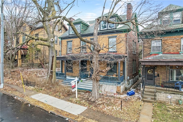 view of front facade featuring a porch and brick siding