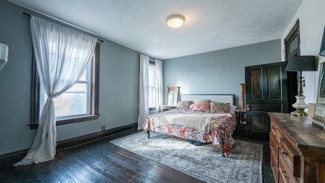 bedroom with dark wood-style flooring and baseboards