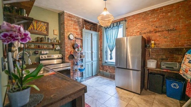 kitchen with appliances with stainless steel finishes, a sink, and brick wall