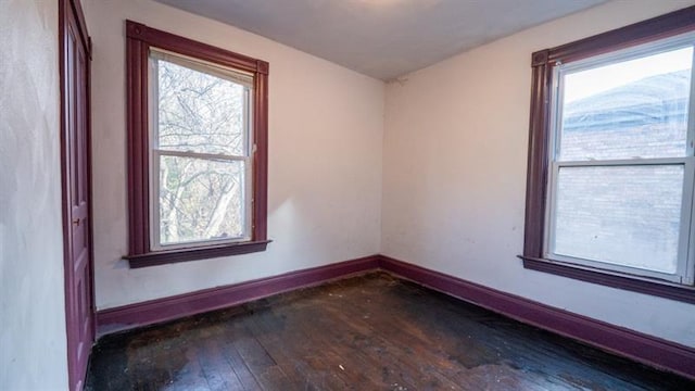 spare room with baseboards and hardwood / wood-style floors