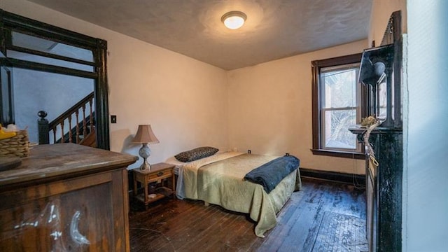 bedroom with dark wood finished floors and baseboards