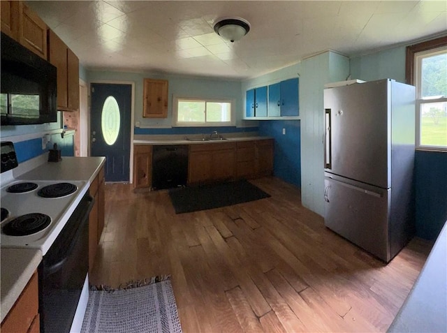 2343 Downing Ln, Hermitage, PA 16148 - kitchen with black appliances, wood finished floors, brown cabinets, and light countertops