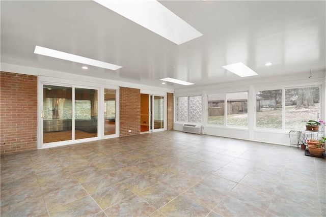 unfurnished sunroom with an AC wall unit and a skylight