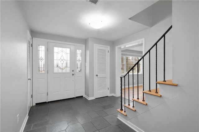 entrance foyer featuring visible vents, stairway, and baseboards