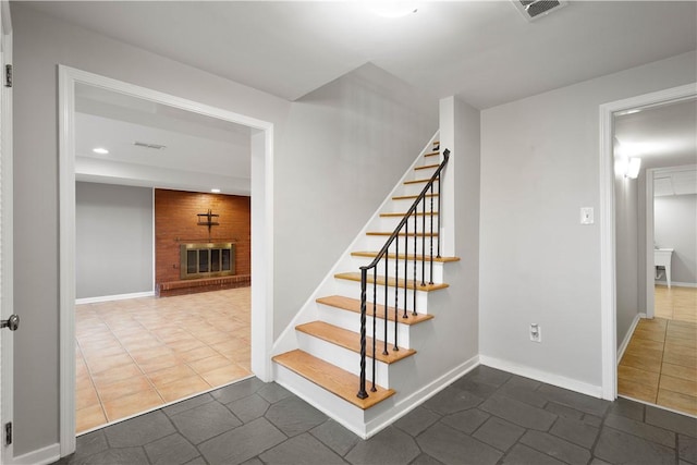 stairway featuring recessed lighting, a brick fireplace, visible vents, and baseboards