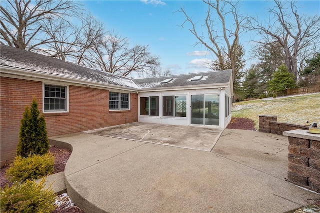 back of house featuring a patio and brick siding